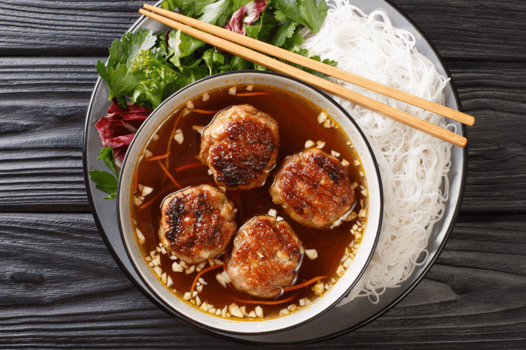 Bun cha is a delicious Vietnamese street food combining flavorful meatballs, rice noodles and dipping sauce.