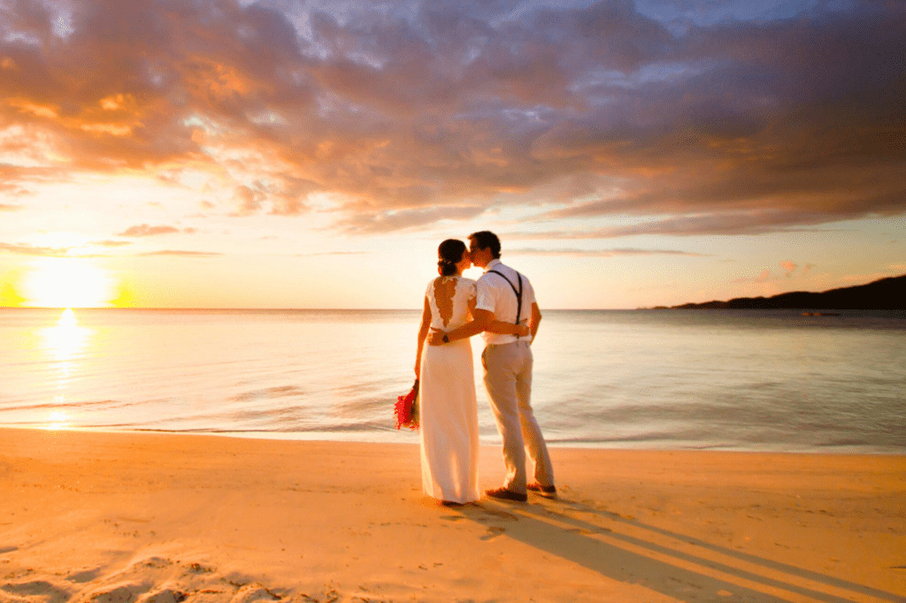 Wedding couple on the beach at sunset on Plantation Island Resort, Fiji