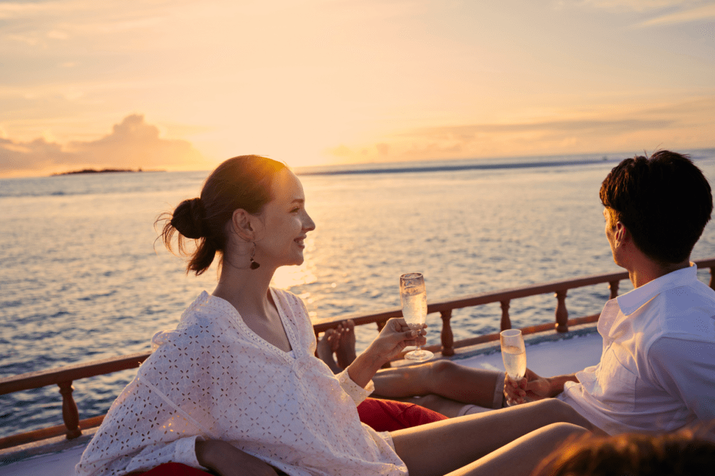 Couple enjoying a sunset cruise at Machchafushi Island Resort & Spa Maldives, The Centara Collection