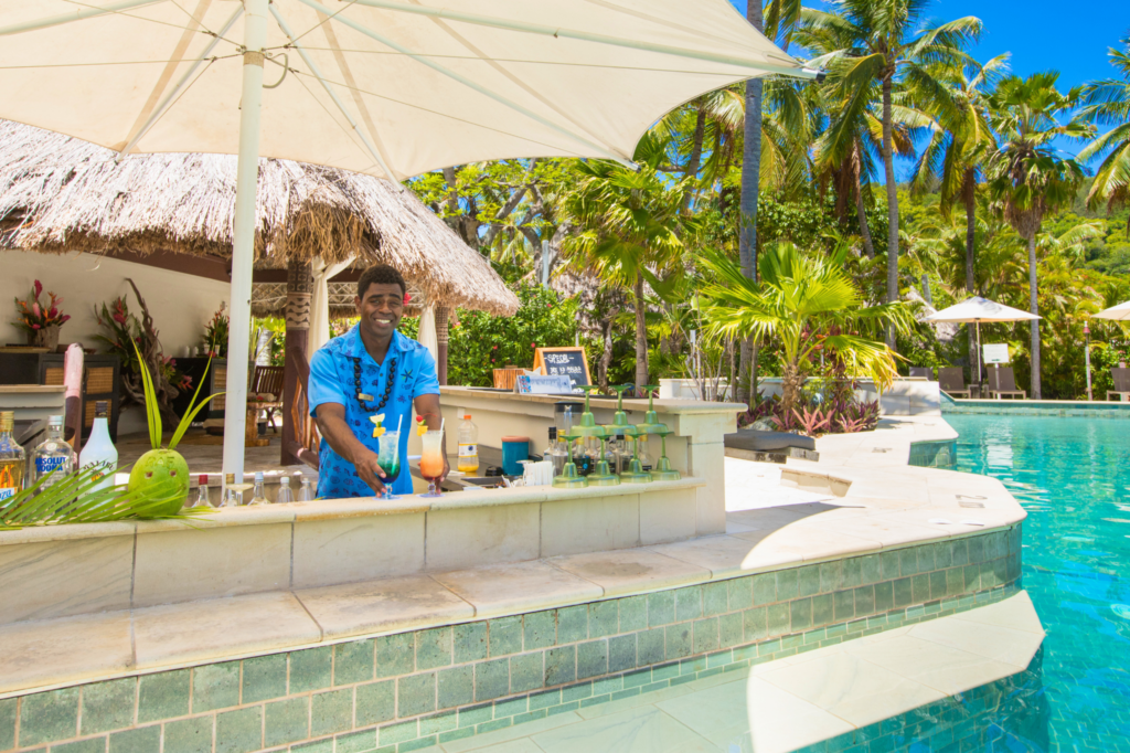 Barman serving cocktails at the swim-up pool bar on Castaway Island Resort, Fiji