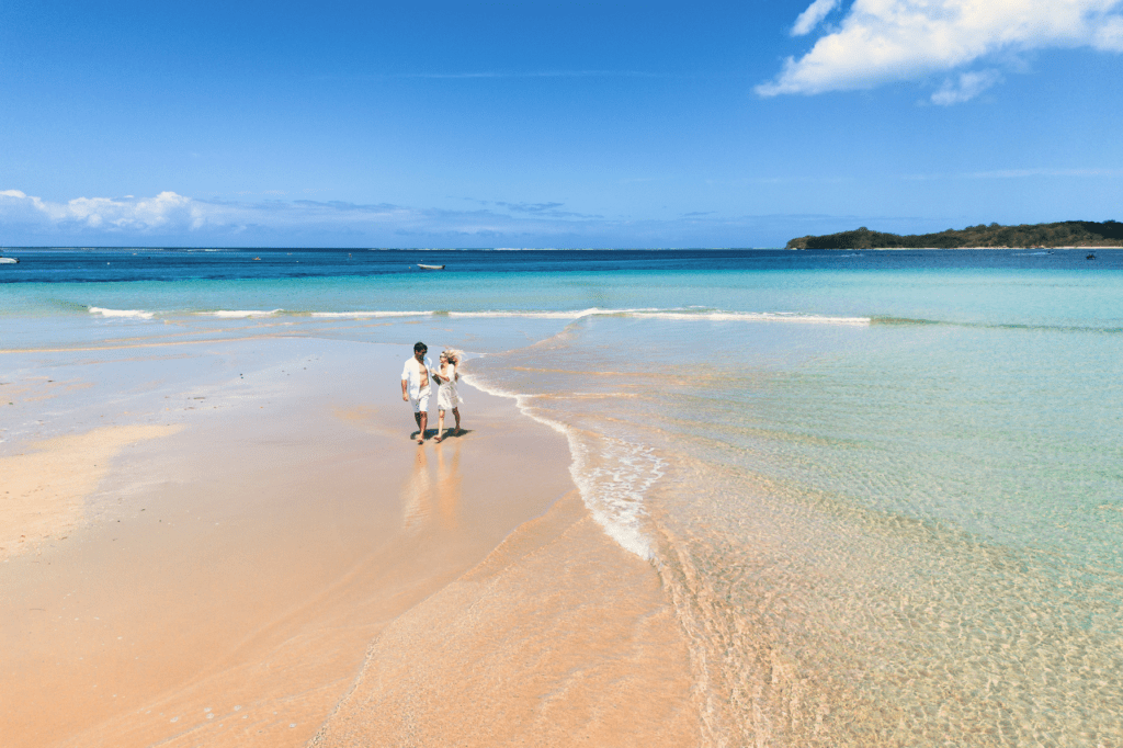 A couple walking along a beach at Shangri-La Yanuca Island Resort, Fiji