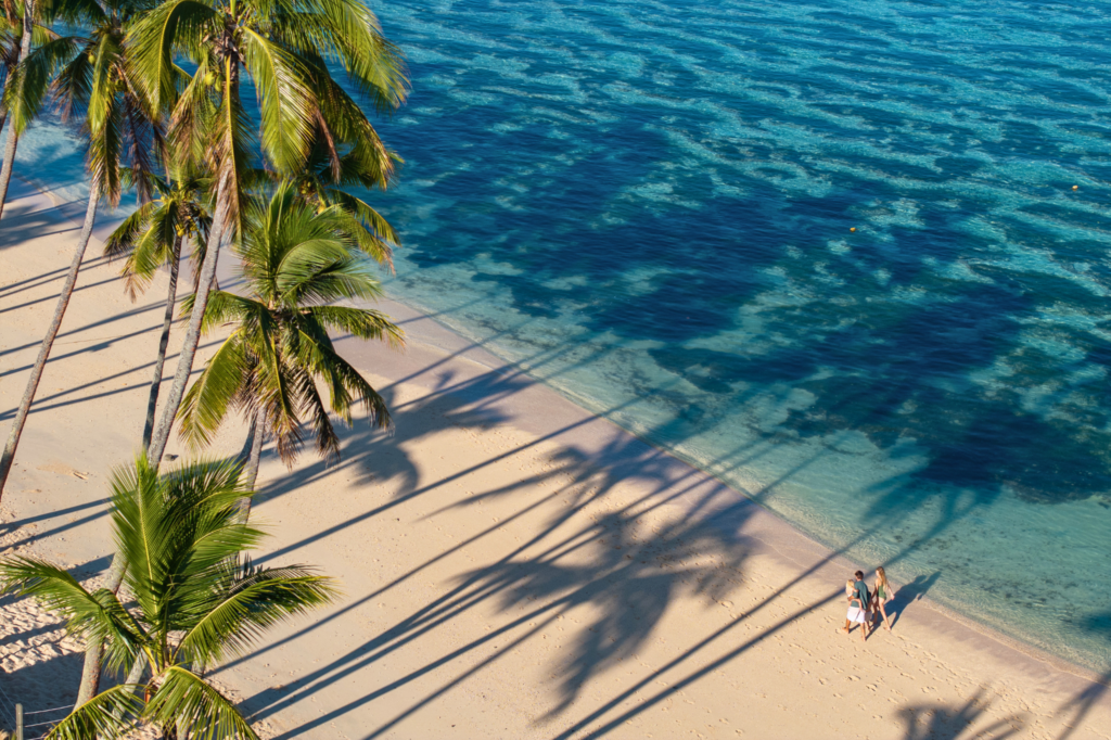 A family walking along the beach at Shangri-La Yanuca Island Fiji