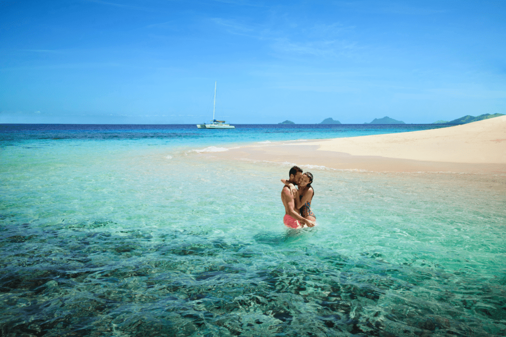 A couple of the shores of a crystal clear beach in Fiji