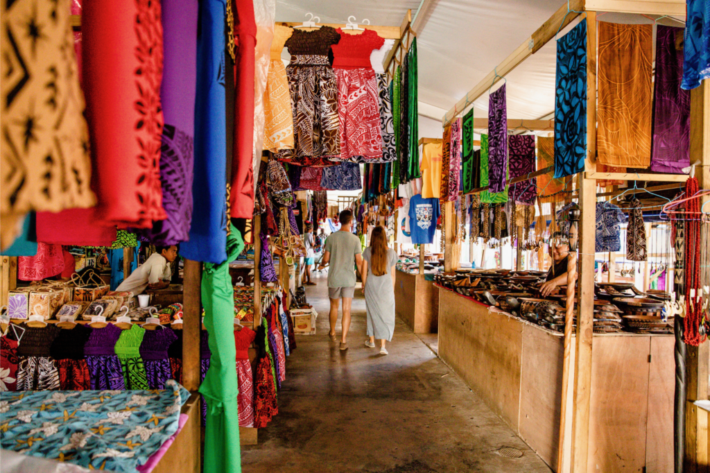 Couple walking through colourful market. Savalalo Flea Market, Upolu.